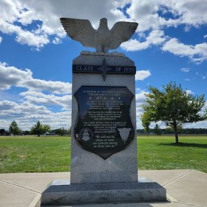 The Airforce Academy Class of 1959 Memorial is crafted from gray and polished black granite. It consists of an upright with a shield with engraved memorial information. The memorial is topped with a sculpture of an eagle with outstretched wings. This memorial is on display at the National Museum of the United States Air Force in Dayton, Ohio.