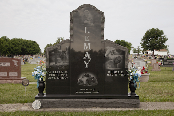 This Custom Companion Upright honoring Lemay is crafted from polished black granite. It consists of three uprights, one large central piece flanked by smaller pieces on either side. Each upright features laser engraved images and memorial information about the decedents. This memorial is suitable for use with traditional interment or cremation.