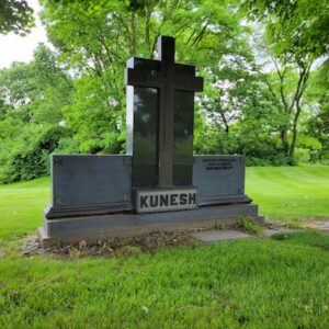 The Kunesh Family Estate Memorial is crafted from polished black and gray granite. It is comprised of 3 components, a central upright with large cross and two flanking uprights with memorial information. This monument is suitable for use with cremation or traditional interment.