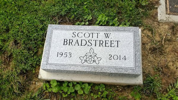 This Single Flush Marker honoring Bradstreet is crafted from gray granite and features an engraving of flowers. This memorial is suitable for use with cremation or traditional interment.