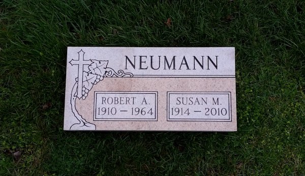 This Companion Flush Marker honoring Neumann is crafted from Rock of Ages pink granite and features an engraving of a cross with ivy accents. This memorial is suitable for use with cremation or traditional interment.