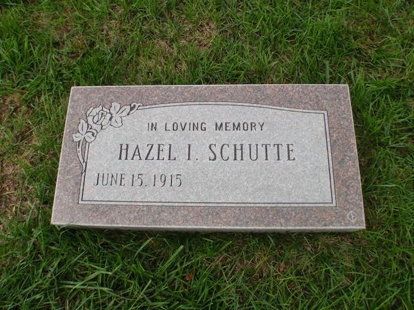 This Flat Marker honoring Schutte is a standard, flat monument rendered in red granite featuring engraved floral scrollwork. It is suitable for use with traditional interment or cremation.