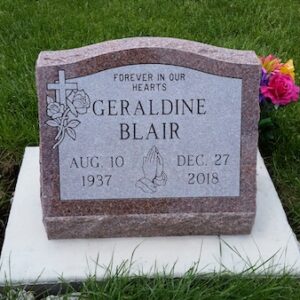 This Single Slant Marker honoring Blair is crafted from Rock of Ages rose granite. It features engravings of a cross, praying hands, and a rose. This memorial is appropriate for use with cremation or traditional interment.