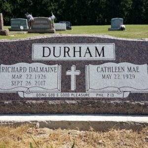 This Companion Slant Marker honoring Durham is crafted from brown granite. It features engravings of bibles with memorial information and a cross. This memorial is suitable for traditional interment or cremation.
