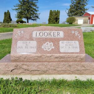 This Companion Slant on a Base honoring Looker is crafted from pink granite. It features engravings of two roses and joined rings. This memorial is suitable for use with cremation or traditional interment.