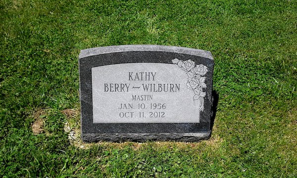 This Single Slant Marker honoring Wilburn is crafted from polished black granite. It features a carving of a bunch of roses along side the memorial information. This memorial is suitable for use with cremation or traditional interment.