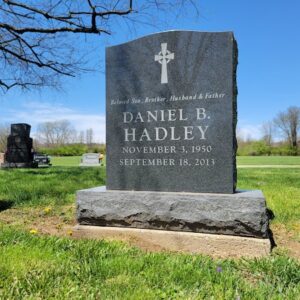 This Single Upright honoring Hadley is crafted from blue granite. It features an engraving of a Celtic cross and is suitable for use with traditional interment or cremation.