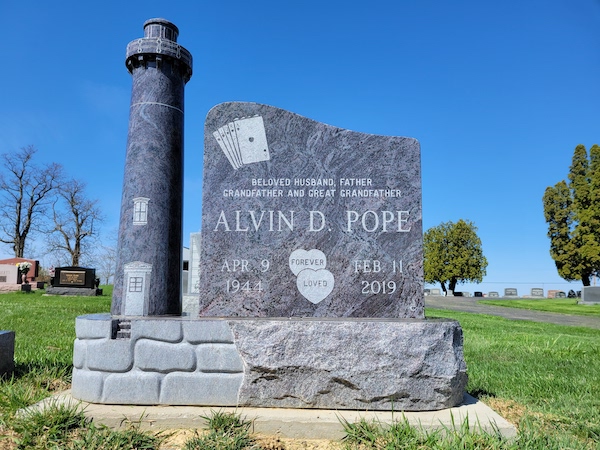 This Custom Single Upright with Lighthouse is crafted from Coral Blue granite. It is in the shape of a lighthouse and is located at Silvercreek Cemetery New in Jamestown, Ohio. This memorial is suitable for use with cremation or traditional interment.