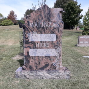 This Custom Upright Memorial in House Roof Shape memorial for the Malinzak/Hicks family was crafted out of Red Multi granite and has a rooftop shaped top. It is located at Spring Grove Cemetery in Cincinnati, Ohio. The side of the memorial has been shape carved for a three dimensional look. This memorial is suitable for cremation or traditional interment.