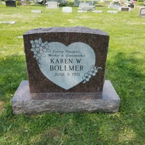 This Single Upright with Heart is crafted from red granite with a polished face and natural edges. A heart with floral trim adorns the face where the decedent's memorial information is recorded. This memorial is suitable for cremation or traditional interment.