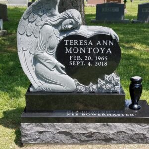 This Custom Single Upright with Vase memorial features a stone shaped in to accommodate the image of a carved angel protecting a heart where the memorial information is presented. The marker, crafted in black polished granite is appropriate for traditional interment or cremation.