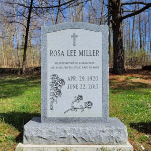 This Single Upright with Cross and Roses is crafted from gray granite and sits on a pedestal. It features a carved cross and rose bunches along with the memorial information for the decedent. This memorial is suitable for cremation or traditional interment.