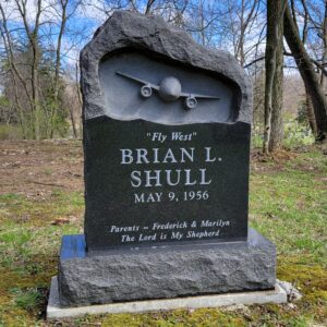 This Custom Single Upright with Jet Airplane memorial is crafted from a half polished and have rough hewn black granite. The top portion of the monument features a sculpted 3 dimensional image of a twin engine jet airplane. This memorial is appropriate for cremation or traditional interment.