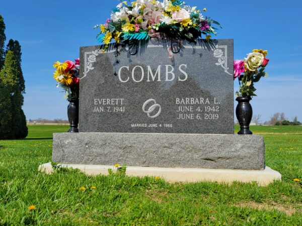 This Companion Upright with Rings memorial is crafted from Rock of Ages Midnight black granite. It is located at Woodlawn Cemetery in Bowersville, Ohio. It has two vases and wedding rings in the middle of the dates.