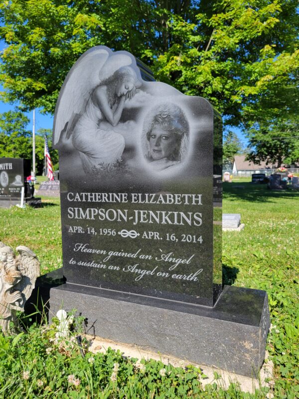 This Custom Single Upright with Laser Engraved Angel is crafted from polished black granite and is shaped to accommodate the angel image. The laser engraving depicts a photo realistic image of the decedent being protected by an angel. This marker is suitable for traditional interment or cremation.