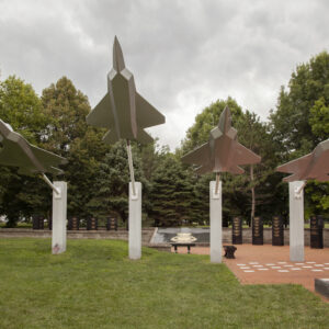 The Entrance at the United States Air Force Museum is crafted from polished black granite and gray granite. It features four sculptures of F-35 aircraft in formation projected from gray granite columns. There are several polished black granite uprights inscribed with memorial and historical information arrayed behind the aircraft installation. You can see this memorial in person at the National Museum of the United States Air Force in Dayton, Ohio.