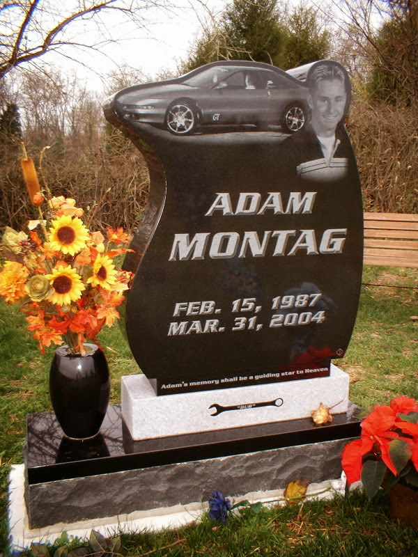 This Custom Single Upright with Wrench is crafted from polished black polished granite and is shaped to conform with images. It features photo realistic laser engraved images of the decedent and a car; it has a carving of a wrench on the base. This memorial is appropriate for use with cremation or traditional interment.
