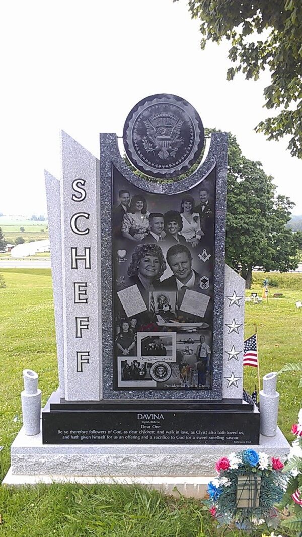 This Custom Companion Upright with the Great Seal of the United States is crafted in two pieces of polished black granite. It features the Great Seal of the United States carved on a circular piece over the upright. The upright features a series of laser engravings of the couple through the years, a photo of Air Force One, and other symbols honoring their lives and careers. This memorial is appropriate for use with cremation or traditional interment.