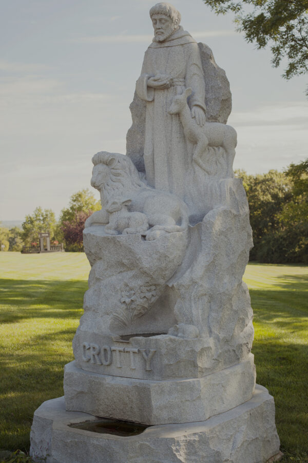 The Crotty Family Estate Memorial is crafted from a large gray boulder of Rock of Ages granite. It features sculptures of a Friar, a doe, a lion, and a lamb. This memorial is appropriate for use with traditional interment or cremation.
