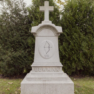 The Bowman Family Estate Memorial is crafted from gray granite and features a four sided upright topped with a free standing cross. It features a prominent carving of a bow on the upright along with a family motto. This memorial is appropriate for use with cremation or traditional interment.