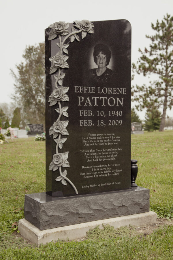 This Custom Single Upright with Carved Roses is crafted from polished black granite and features a photo realistic image of the decedent achieved through the process of laser engraving. This memorial is appropriate for use with traditional interment or cremation.