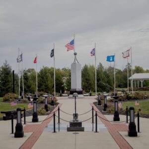 The Spencerville Veterans Memorial is crafted from black polished granite. It is a sculpture of boots, a rifle, and a helmet balanced on the rifle. You can see this memorial in person in Spencerville, Ohio.