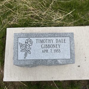 This single flush marker crafted from gray granite features a single carved rose. This memorial is appropriate for use with traditional interment or cremation.