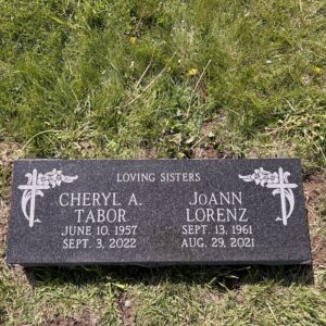 This companion flush marker in black granite features dual, carved crosses entwined with flowers. This memorial is appropriate for use with cremation or traditional interment.