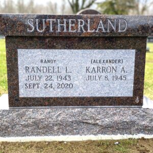 This upright companion memorial honors the Sutherlands and is crafted from Carnelian Mahogany granite. The memorial features a simple form with a flat top and is suitable for honoring those who have been cremated.